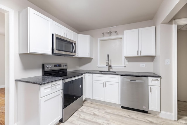 336 Biltmore Ave, Lynchburg, VA 24502 - kitchen with light wood-style flooring, a sink, stainless steel appliances, white cabinets, and baseboards
