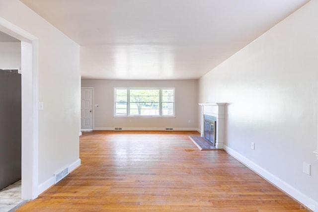 336 Biltmore Ave, Lynchburg, VA 24502 - unfurnished living room featuring light wood-style flooring, a glass covered fireplace, baseboards, and visible vents