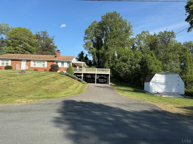 view of front of house featuring a chimney, an outbuilding, a shed, and a front lawn