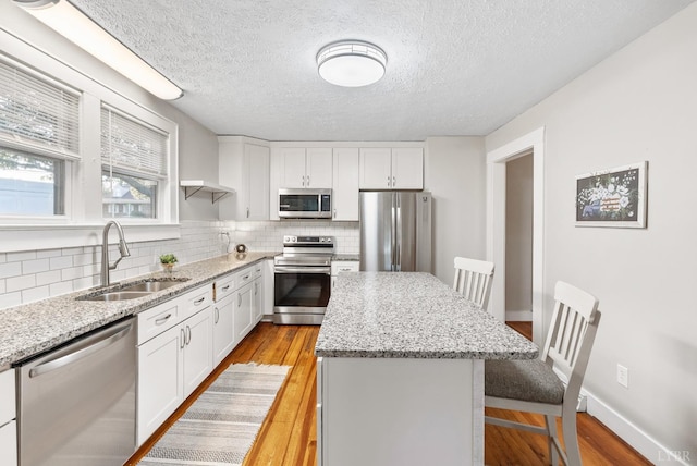 507 Henry St, Gretna, VA 24557 - kitchen featuring a sink, stainless steel appliances, a breakfast bar area, decorative backsplash, and a center island
