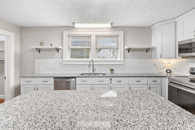507 Henry St, Gretna, VA 24557 - kitchen with open shelves, white cabinetry, appliances with stainless steel finishes, and a sink