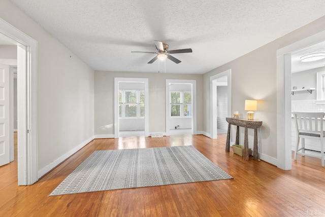 507 Henry St, Gretna, VA 24557 - unfurnished living room with a ceiling fan, baseboards, wood-type flooring, and a textured ceiling