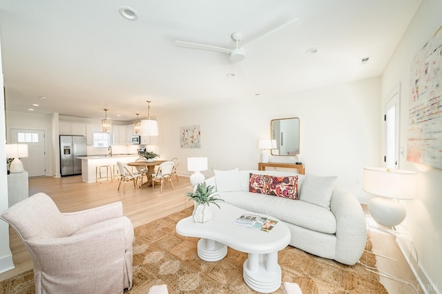 living room featuring ceiling fan, light wood-type flooring, visible vents, and recessed lighting
