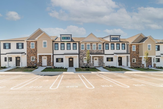 view of property with stone siding and uncovered parking