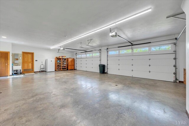 122 Gravelly Ridge Rd, Troutville, VA 24175 - garage featuring freestanding refrigerator, a sink, and a garage door opener