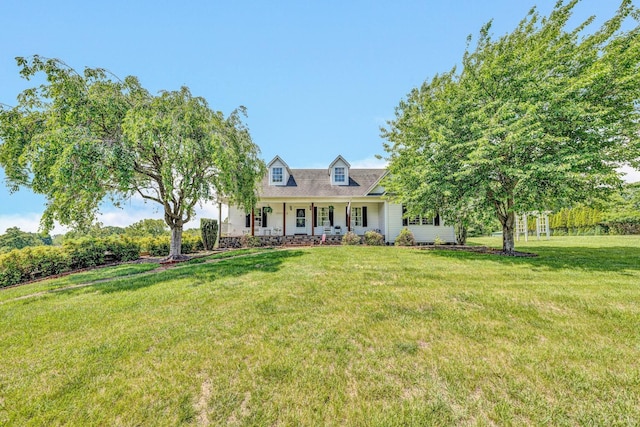 new england style home featuring a front lawn and covered porch