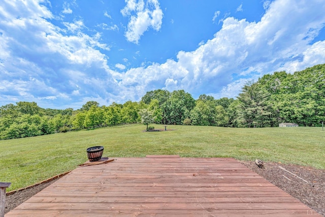 deck with a wooded view and a lawn