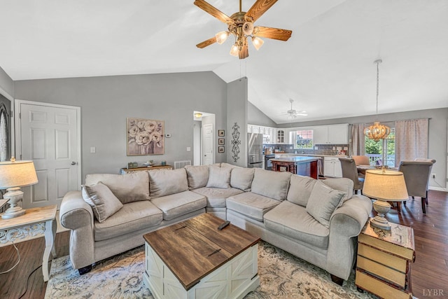 living area featuring lofted ceiling, light wood-style floors, visible vents, and ceiling fan with notable chandelier