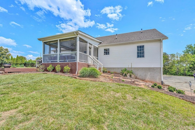 rear view of house featuring a lawn and a sunroom