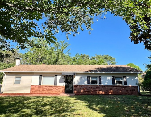 single story home with a chimney, brick siding, and a front yard