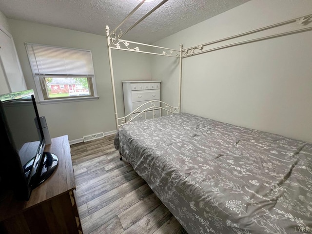 139 Abbitts Dr, Madison Heights, VA 24572 - bedroom featuring wood finished floors, a textured ceiling, and baseboards