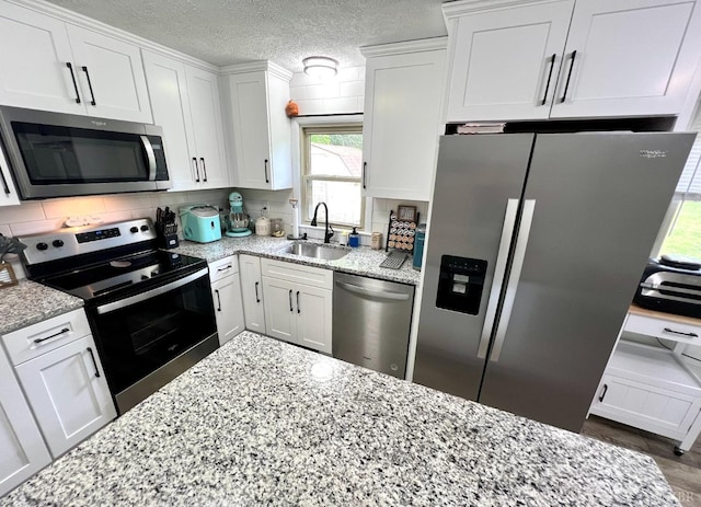 139 Abbitts Dr, Madison Heights, VA 24572 - kitchen featuring stainless steel appliances, a sink, white cabinets, light stone counters, and a textured ceiling
