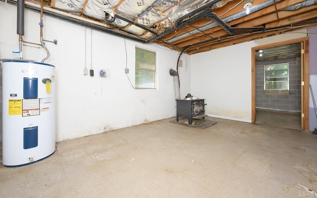 basement featuring electric water heater and a wood stove