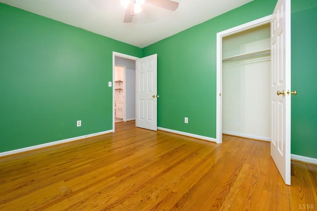 unfurnished bedroom with a closet, light wood-style floors, baseboards, and ceiling fan