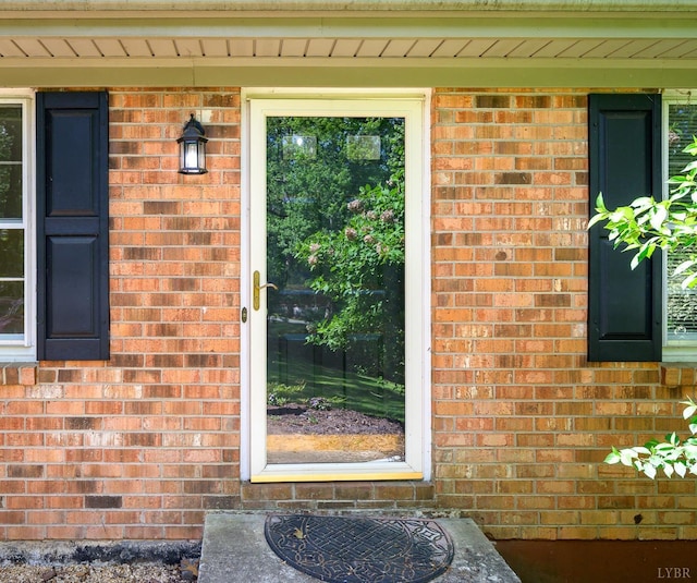 view of exterior entry with brick siding
