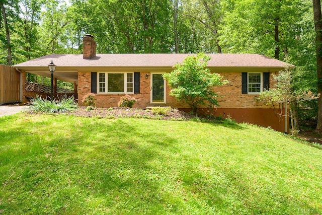 ranch-style home featuring a front lawn, brick siding, a chimney, and a carport
