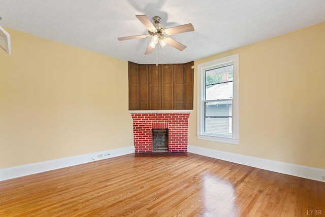 600 9th St, Altavista, VA 24517 - unfurnished living room featuring wood finished floors, a fireplace, a textured ceiling, baseboards, and ceiling fan