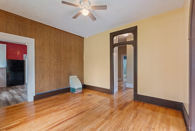 600 9th St, Altavista, VA 24517 - unfurnished room featuring wood finished floors, a ceiling fan, wood walls, baseboards, and arched walkways