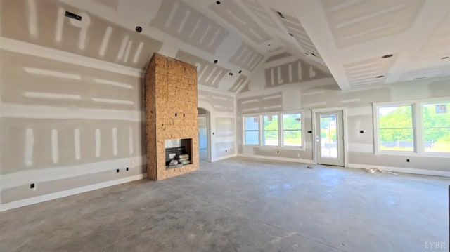 25 Stoney Ridge Blvd, Forest, VA 24551 - unfurnished living room featuring healthy amount of natural light, unfinished concrete floors, high vaulted ceiling, a multi sided fireplace, and arched walkways