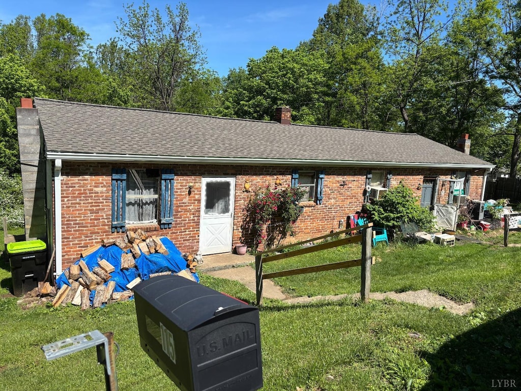 view of front of property featuring a chimney, brick siding, and roof with shingles