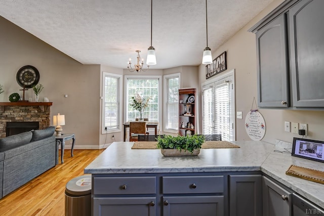 22 Semmes Ct, Rustburg, VA 24588 - kitchen featuring a peninsula, a chandelier, gray cabinets, open floor plan, and a textured ceiling