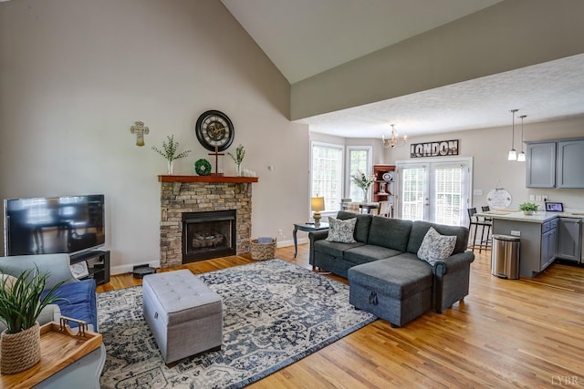 22 Semmes Ct, Rustburg, VA 24588 - living area featuring a chandelier, light wood-style flooring, high vaulted ceiling, and a stone fireplace