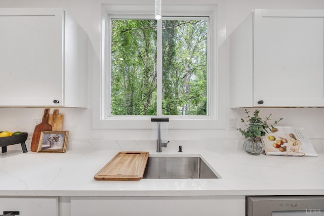 kitchen featuring dishwasher and white cabinetry