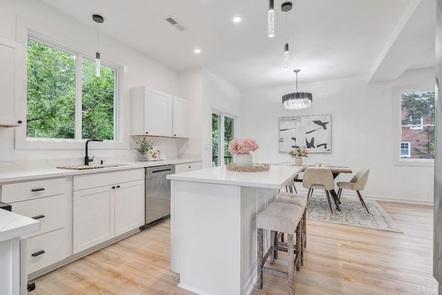 kitchen with dishwasher, light wood finished floors, plenty of natural light, and recessed lighting