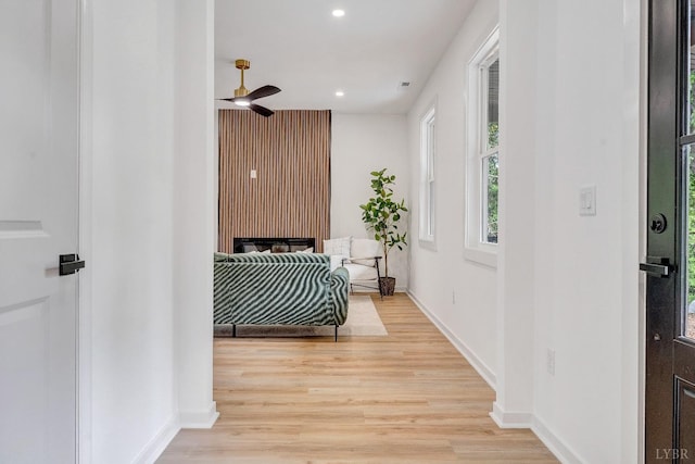 corridor featuring light wood-style floors, recessed lighting, and baseboards