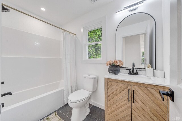 bathroom featuring toilet, vanity, shower / bath combo with shower curtain, baseboards, and tile patterned floors