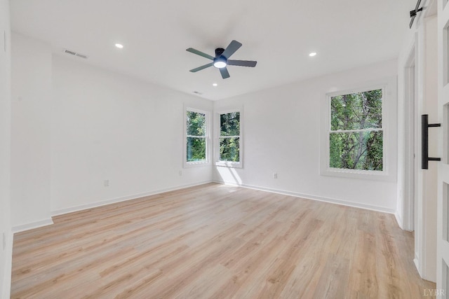 spare room with plenty of natural light, light wood-style floors, ceiling fan, baseboards, and recessed lighting