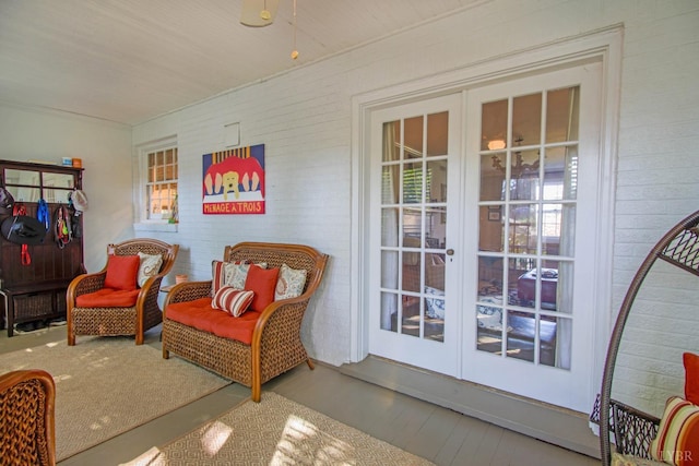 living area featuring french doors, plenty of natural light, and wood finished floors