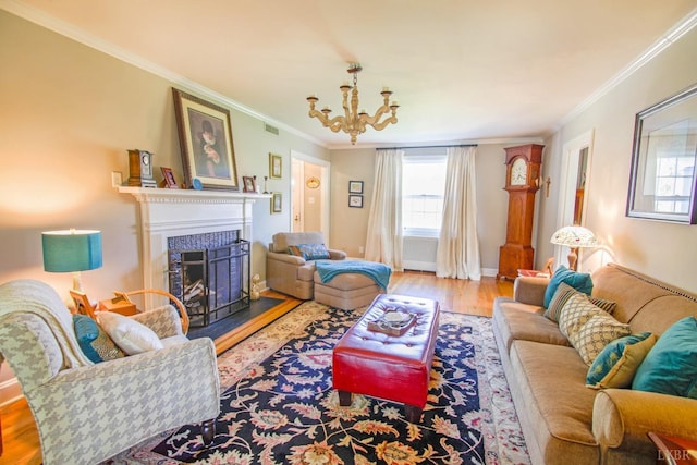 living area featuring crown molding, plenty of natural light, a fireplace, wood finished floors, and a chandelier