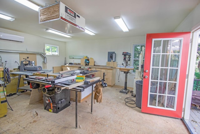miscellaneous room with a workshop area, a wall unit AC, and a heating unit