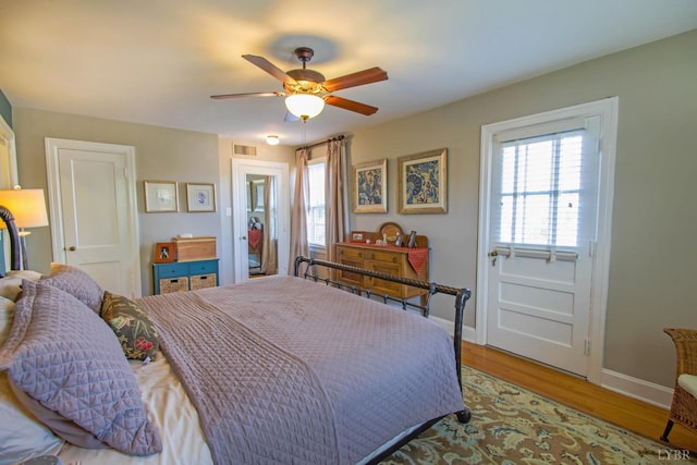 bedroom with baseboards, wood finished floors, and a ceiling fan