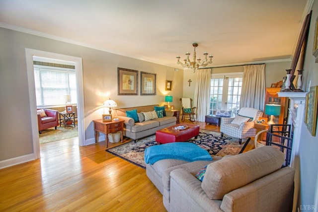 living area featuring ornamental molding, a chandelier, light wood-type flooring, and baseboards