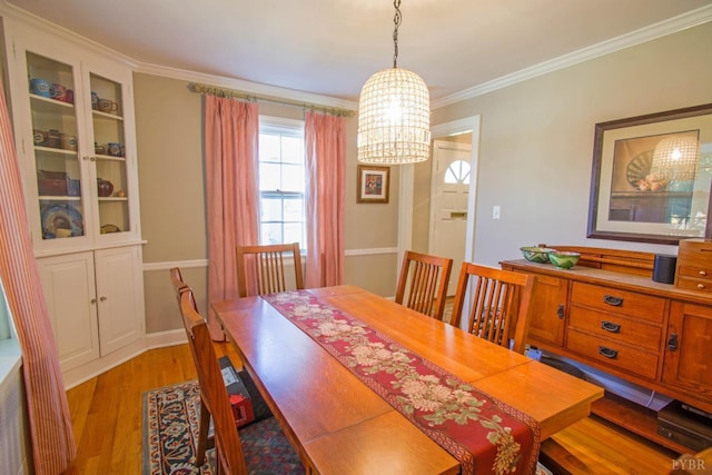 dining space featuring a chandelier, ornamental molding, plenty of natural light, and light wood-style flooring