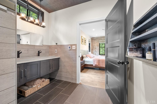 1228 Mill Dam Ln, Forest, VA 24551 - bathroom featuring tile walls, double vanity, wood finished floors, ensuite bath, and wainscoting