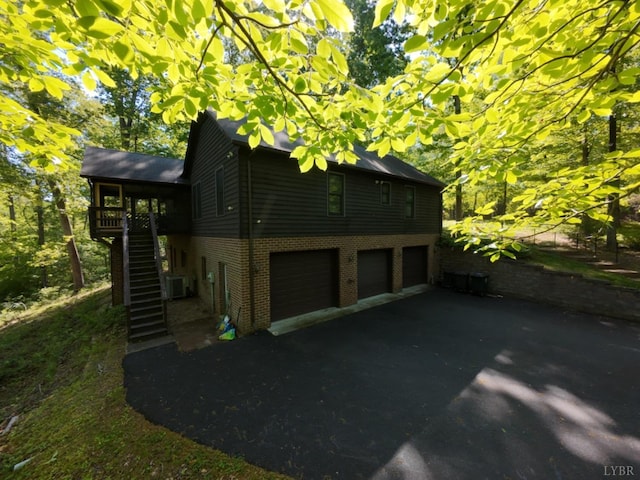 2130 Burnt Bridge Rd, Lynchburg, VA 24503 - view of home's exterior featuring stairs, brick siding, central air condition unit, a garage, and driveway