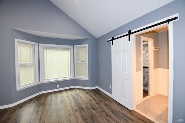 2130 Burnt Bridge Rd, Lynchburg, VA 24503 - unfurnished bedroom with a barn door, dark wood-style flooring, and lofted ceiling