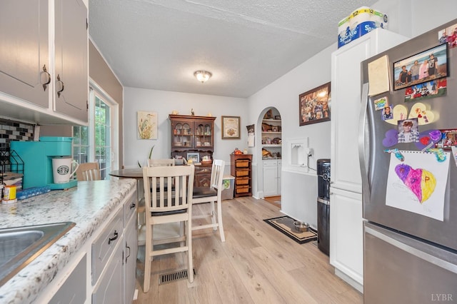 500 Leftwich St, Gretna, VA 24557 - kitchen featuring freestanding refrigerator, a textured ceiling, light wood-style flooring, a sink, and white cabinetry