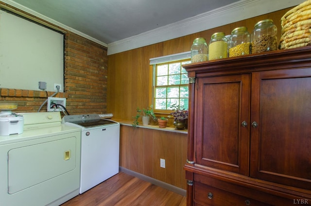 1426 Nelson Dr, Lynchburg, VA 24502 - laundry room featuring independent washer and dryer, cabinet space, light wood-style floors, ornamental molding, and brick wall