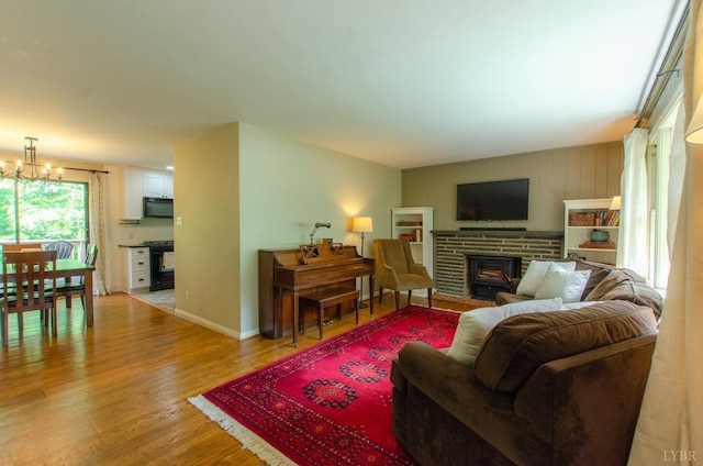 1426 Nelson Dr, Lynchburg, VA 24502 - living room with light wood finished floors, a chandelier, and a brick fireplace