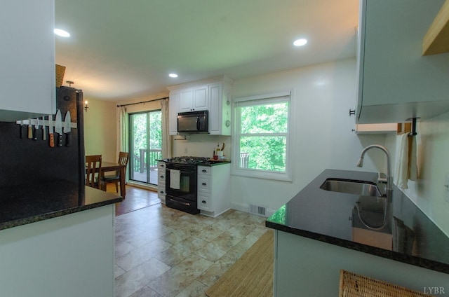 1426 Nelson Dr, Lynchburg, VA 24502 - kitchen with black appliances, plenty of natural light, white cabinets, and recessed lighting