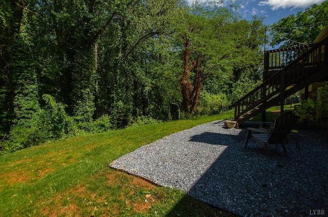 1426 Nelson Dr, Lynchburg, VA 24502 - view of grassy yard with stairway, a deck, a patio area, and a view of trees