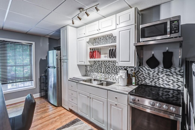206 Bella Ct, Lynchburg, VA 24502 - kitchen featuring appliances with stainless steel finishes, a sink, light wood finished floors, decorative backsplash, and white cabinets