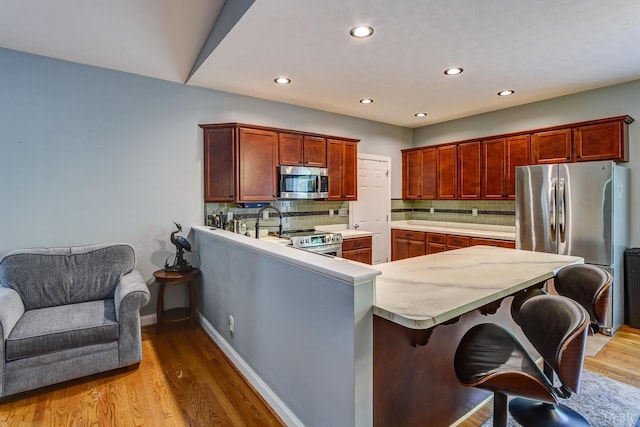 206 Bella Ct, Lynchburg, VA 24502 - kitchen with appliances with stainless steel finishes, light countertops, light wood-style flooring, tasteful backsplash, and recessed lighting