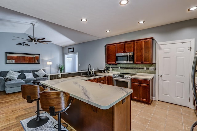 206 Bella Ct, Lynchburg, VA 24502 - kitchen with a sink, stainless steel appliances, a peninsula, lofted ceiling, and a kitchen breakfast bar