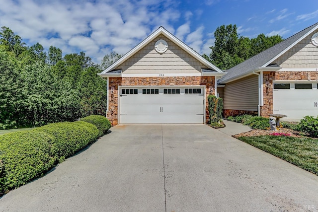 206 Bella Ct, Lynchburg, VA 24502 - view of front of property with stone siding, concrete driveway, a garage, and an outbuilding