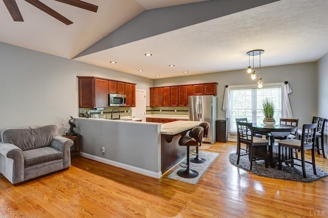 206 Bella Ct, Lynchburg, VA 24502 - kitchen featuring appliances with stainless steel finishes, a peninsula, light wood-style floors, lofted ceiling, and ceiling fan
